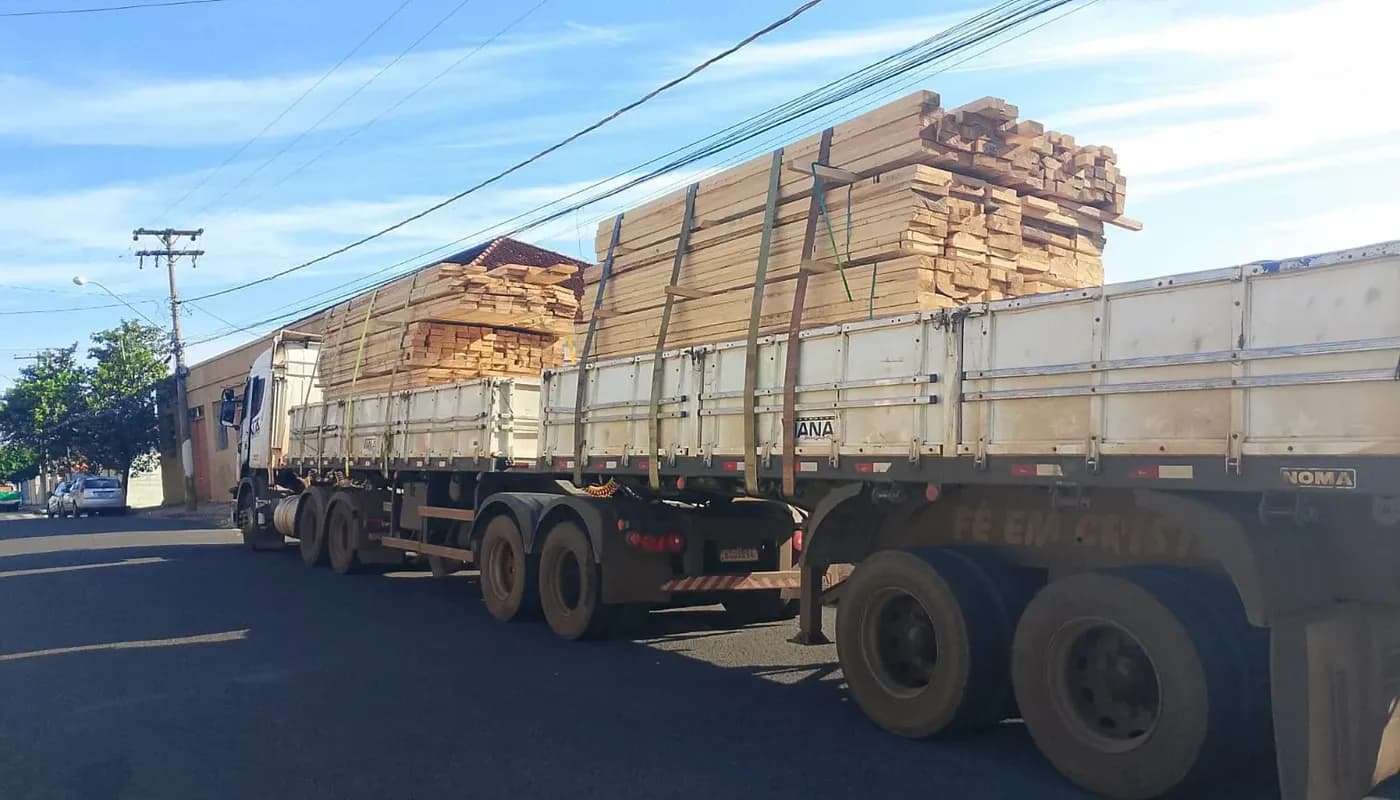 Carreta com madeira serrada estacionada na rua para entrega